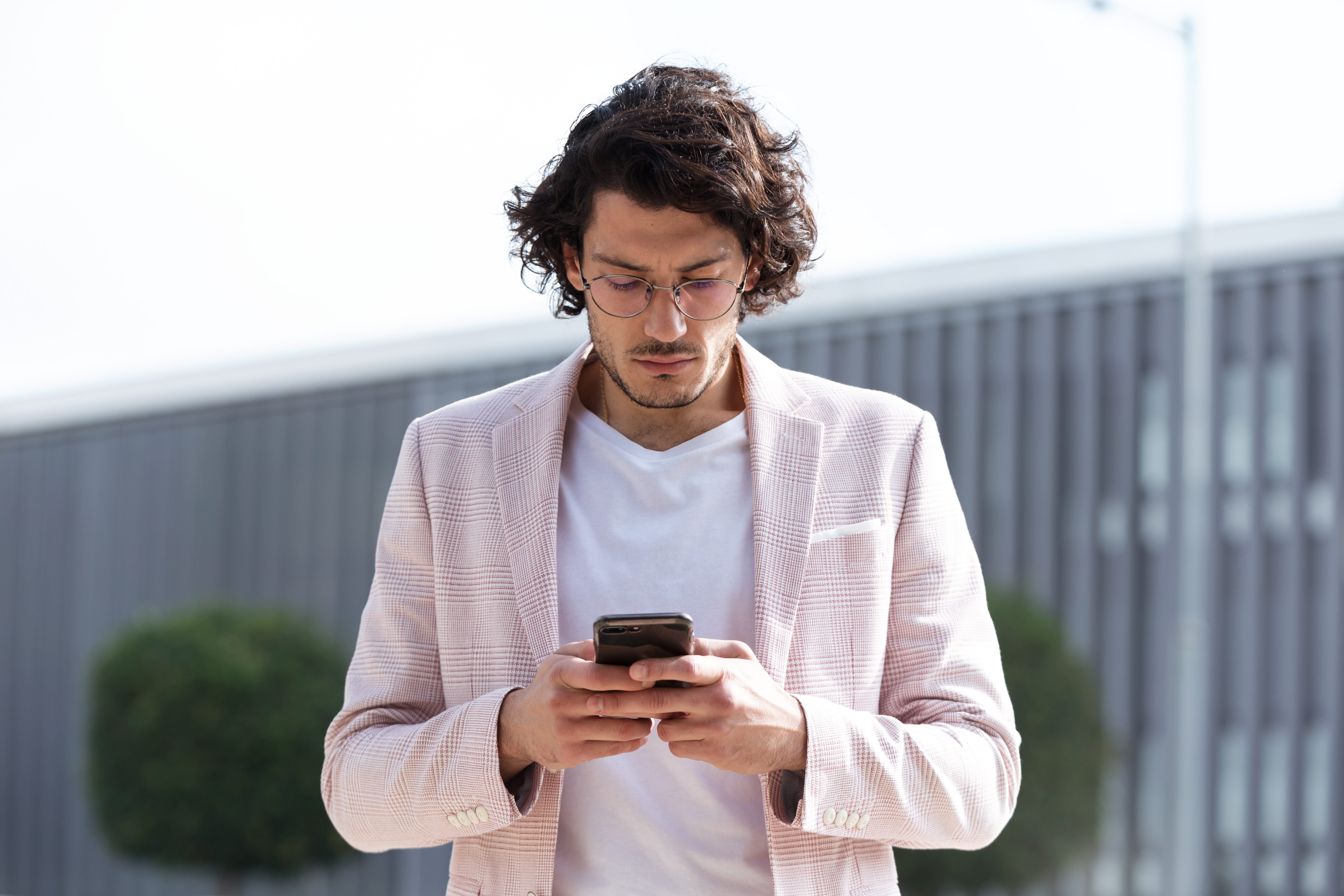 Gehender Mann, der auf das Smartphone schaut