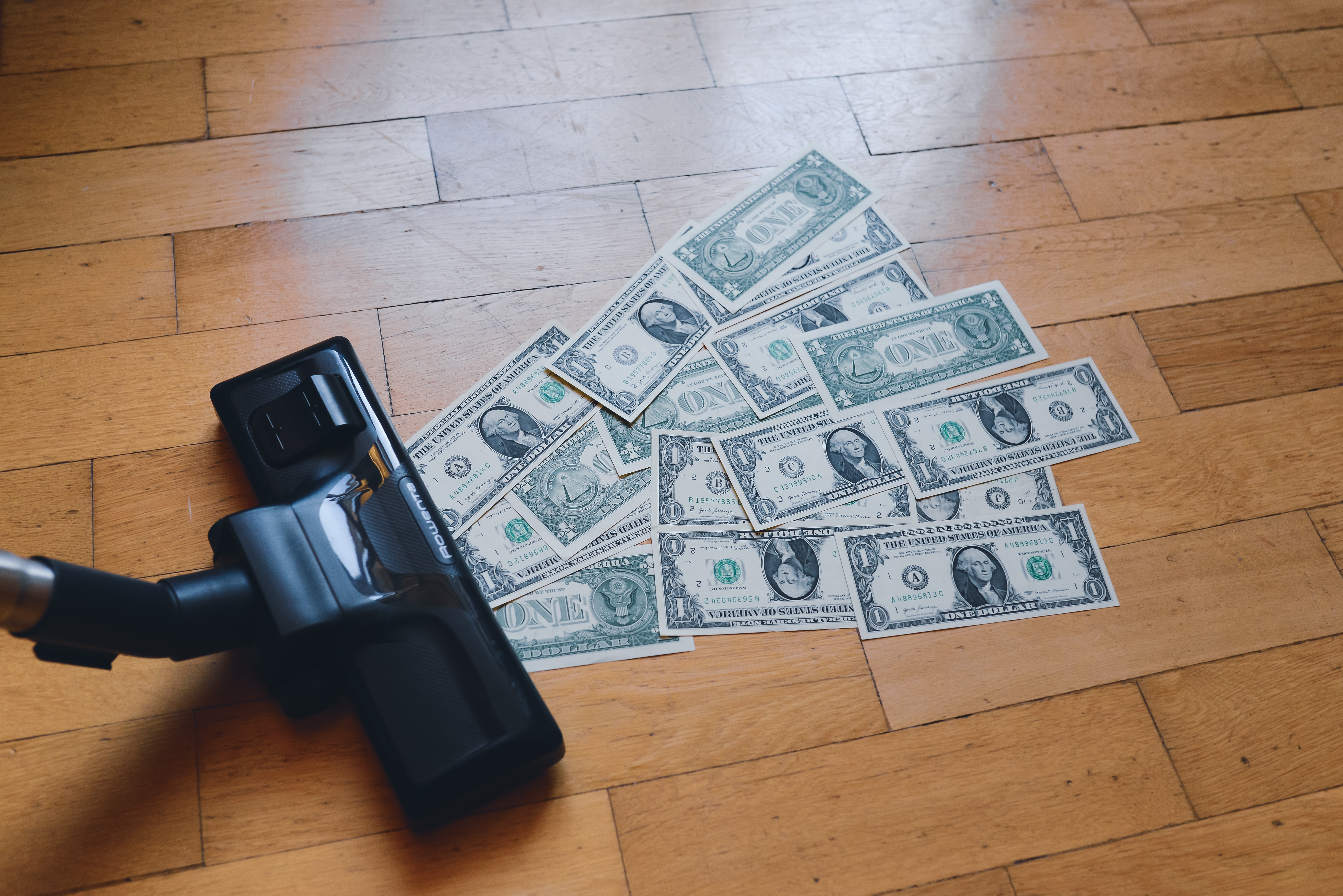 Staubsauger saugt Dollarscheine ein